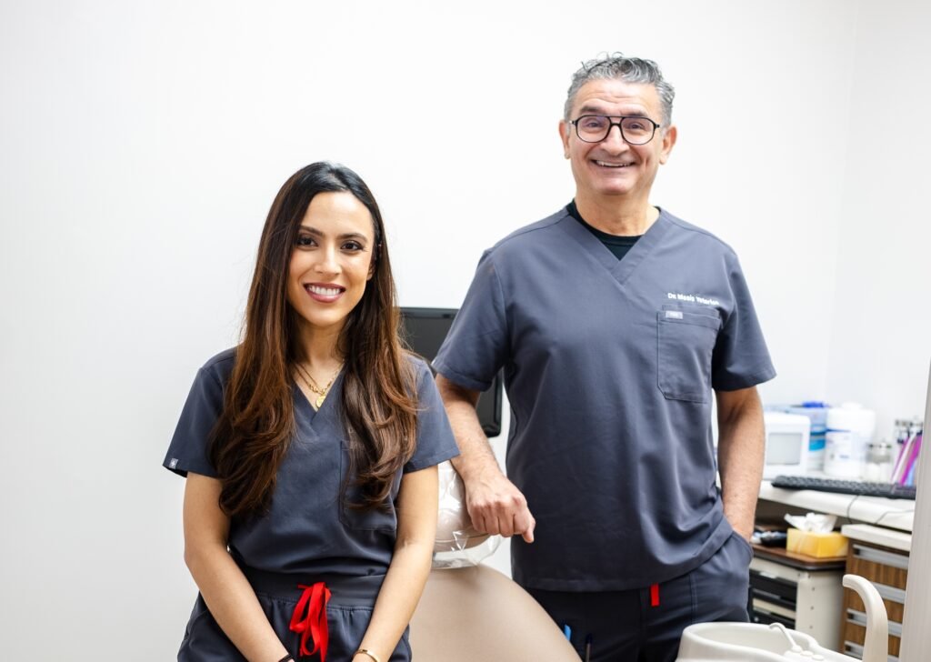 WCD_GWD_'-25 copy Two dental professionals in navy uniforms standing together in modern Greenwich Dental Studio treatment room space.