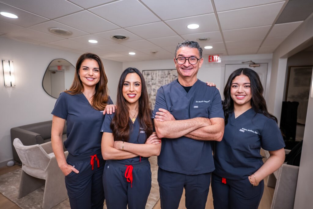 WCD_GWD_'-28 Greenwich Dental Studio team portrait with four smiling clinicians in navy uniforms inside the practice space.